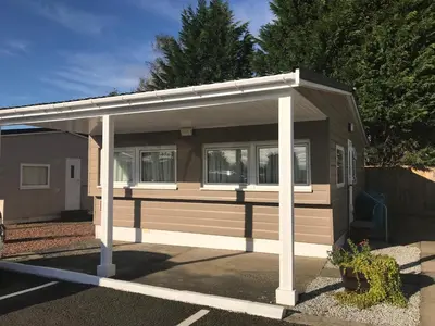 a small house with awning in a parking lot at Red Deer Village Holiday Park - 2 Bedroom, Self-Catering Chalet in Steps