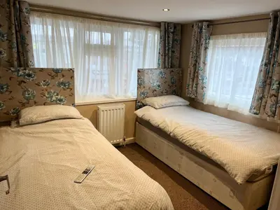 a bedroom with two beds and a window at Red Deer Village Holiday Park - 2 Bedroom, Self-Catering Chalet in Steps