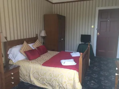 a hotel room with a bed with towels on it at Broom Lodge in Largs