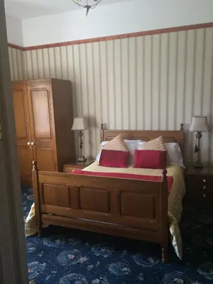 a bedroom with a large bed with two red pillows at Broom Lodge in Largs