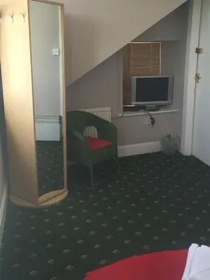 a hotel room with a chair and a television at Broom Lodge in Largs