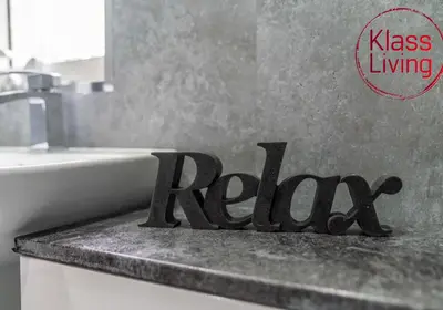 a bathroom sign sitting on top of a sink at Broomfield Apartment by Klass Living Airdrie in Airdrie