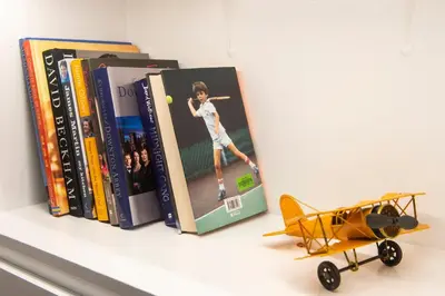 a shelf with books and a toy airplane on it at Two Bed Stylish Apartment in Heart of West End in Glasgow
