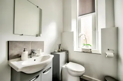 a white bathroom with a sink and a toilet at Two Bed Stylish Apartment in Heart of West End in Glasgow