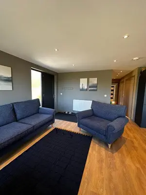a living room with two blue couches and a rug at Spacious 3-Bedroom Chalet on Country Estate near Glasgow - sleeps 6 in Glasgow