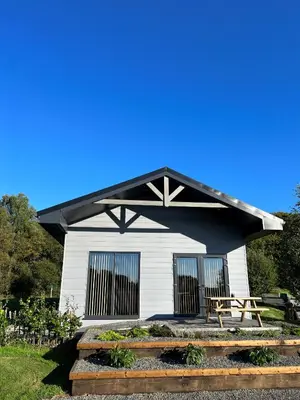 a white building with a picnic table in front of it at Spacious 3-Bedroom Chalet on Country Estate near Glasgow - sleeps 6 in Glasgow