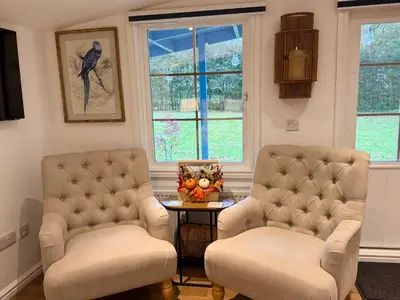 two chairs and a table in a room with windows at Oak View Lodge: Cosy, Countryside Retreat in Maybole