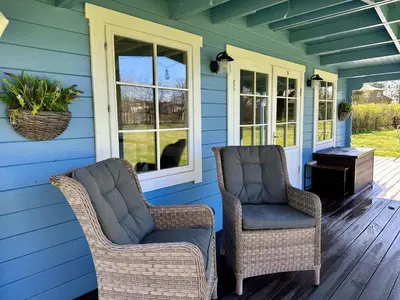 two chairs on the front porch of a house at Oak View Lodge: Cosy, Countryside Retreat in Maybole