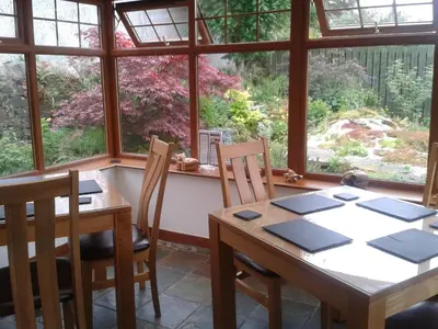 a dining room with a table and chairs and a window at Middleton House Bed and Breakfast in Auchterarder