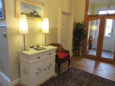 a living room with a table with two lamps and a chair at Middleton House Bed and Breakfast in Auchterarder