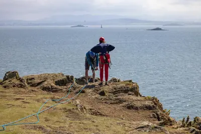 a man standing on a cliff looking at the ocean at Seaside Place, Aberdour in Aberdour