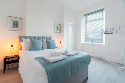 a bedroom with a large bed with towels on it at Dyke Apartment in Bailleston