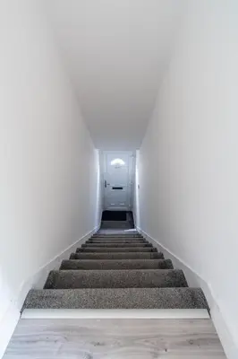 a staircase in an empty building with a door at Locksley House in Knightswood