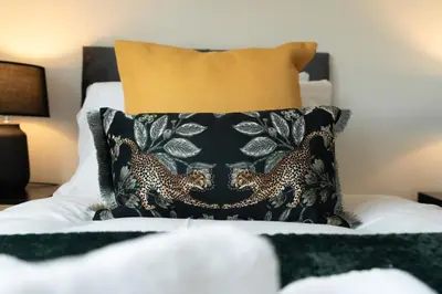 a bedroom with a black pillow on a bed at Locksley House in Knightswood