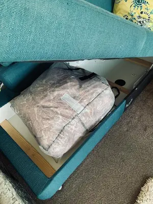 a bag is sitting in a box under a bed at Facing Glasgow Green spacious Apartment Free parking in Glasgow