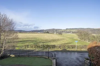 a pond with a fence and a grassy field at Springfield Lodge Bed and Breakfast in Stirling