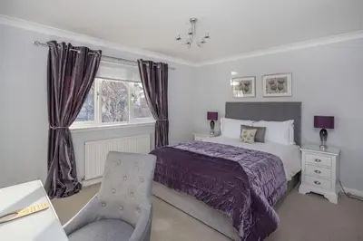 a bedroom with a bed and a chair at Springfield Lodge Bed and Breakfast in Stirling