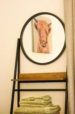a mirror on a shelf with a picture of a cow at Sea View Farmhouse in Cushendun