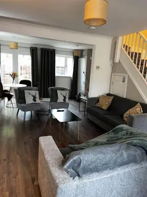 a living room with a couch and a table at 15 min drive to airport 20 min to Loch Lomond and city center in Old Kilpatrick