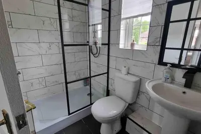 a bathroom with a toilet and a sink and a shower at 15 min drive to airport 20 min to Loch Lomond and city center in Old Kilpatrick
