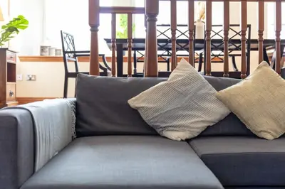 a blue couch with two pillows on top of it at Cromwell Corner - Donnini Apartments in Ayr
