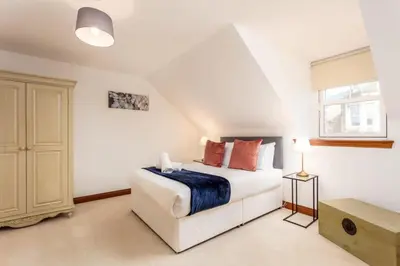 a white bedroom with a bed and a window at Cromwell Corner - Donnini Apartments in Ayr