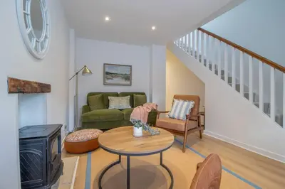a living room with a couch and a table at Henry Bell - Cosy 2-bedroom cottage in Helensburgh
