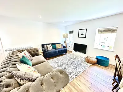 a living room with a couch and a tv at Luxury Smugglers Cottage in the Heart of Inveraray Sleeps 4 in 2 Bedrooms in Inveraray