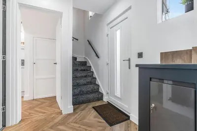 a living room with a staircase and a fireplace at Parkside 2 bedroom house near Dunfermline & Edinburgh in Dunfermline