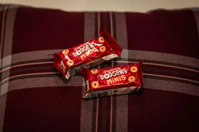 two pieces of candy bars sitting on a bed at Tynecastle Park Hotel in Edinburgh