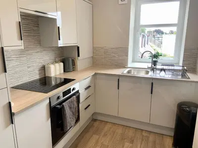 a kitchen with white cabinets and a sink and a window at Stunning Apartment in Callander in Callander