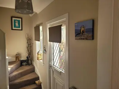 a hallway with stairs and a door with a window at Spacious 2 bedroom house on the edge of Balloch in Balloch