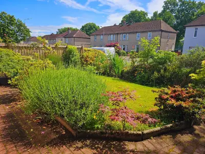 a garden with flowers and plants in a yard at Spacious 2 bedroom house on the edge of Balloch in Balloch