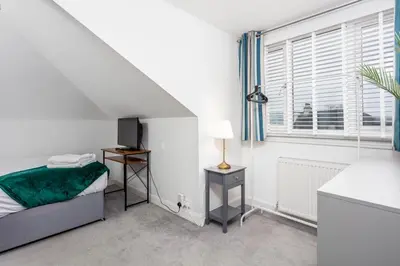 a white bedroom with a bed and a window at Berelands House - Donnini Apartments in Prestwick