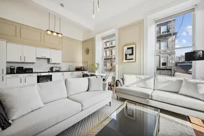 a living room with two couches and a kitchen at (G1) Elegant 2 bed Blythswood Apartment in Glasgow
