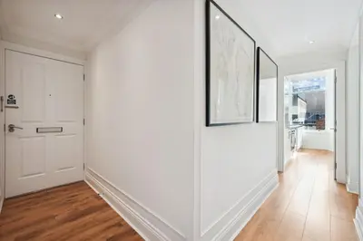 a hallway with white walls and wooden floors at (G3) Grand 2 bed Blythswood Apartment in Glasgow