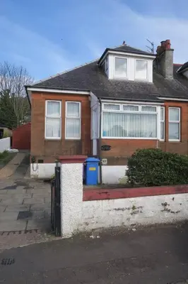 a brown house with a blue trash can in front of it at Cumbrae View House (Licence no NA00109F) in Largs