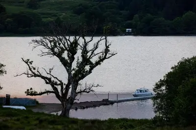 a boat is docked at a dock on a lake at Blar Cottage (Private Sauna + Fast Starlink Wifi) in Hayfield