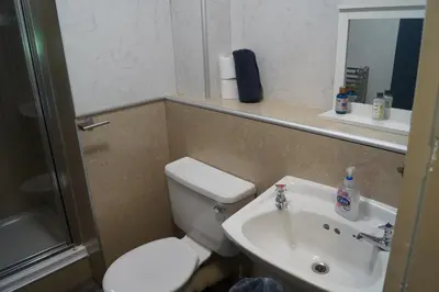 a small bathroom with a toilet and a sink at Garnock 1 in Beith