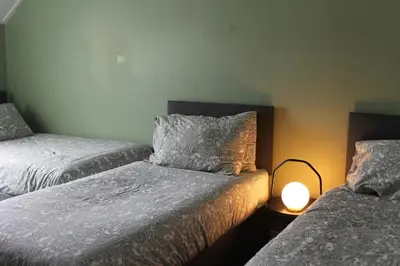 a bedroom with two beds and a lamp on a table at Garnock 1 in Beith