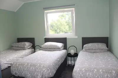 two twin beds in a room with a window at Garnock 1 in Beith