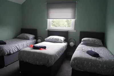 two twin beds in a room with a window at Garnock 2 in Beith