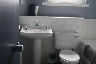 a bathroom with a white toilet and a sink at Garnock 2 in Beith