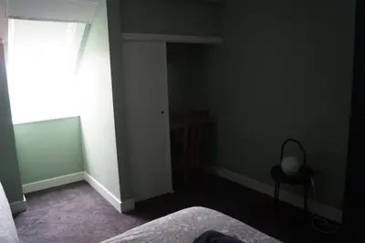a bedroom with green walls and a bed and a window at Garnock 2 in Beith