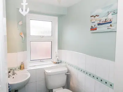 a bathroom with a toilet and a sink and a window at The Old Rectory in Largs