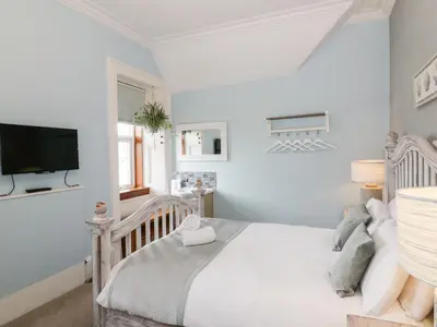 a bedroom with a crib and a tv on the wall at The Old Rectory in Largs