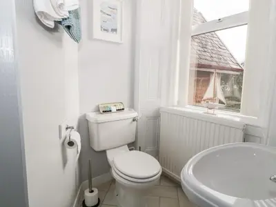 a bathroom with a toilet and a sink and a window at The Old Rectory in Largs