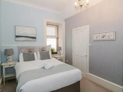 a bedroom with a bed and a table and a window at The Old Rectory in Largs