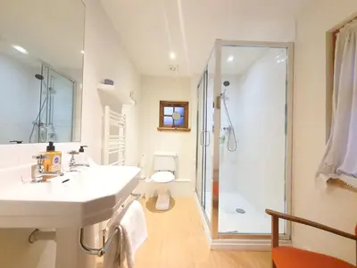a white bathroom with a sink and a shower at Edinburgh 2-Bedroom Cottage with Parking - Ground Floor in Edinburgh