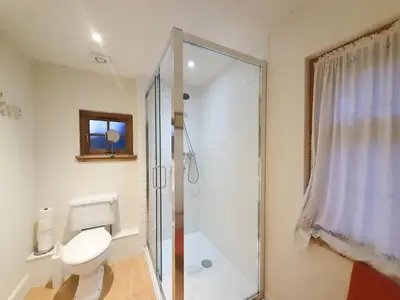 a bathroom with a toilet and a glass shower at Edinburgh 2-Bedroom Cottage with Parking - Ground Floor in Edinburgh